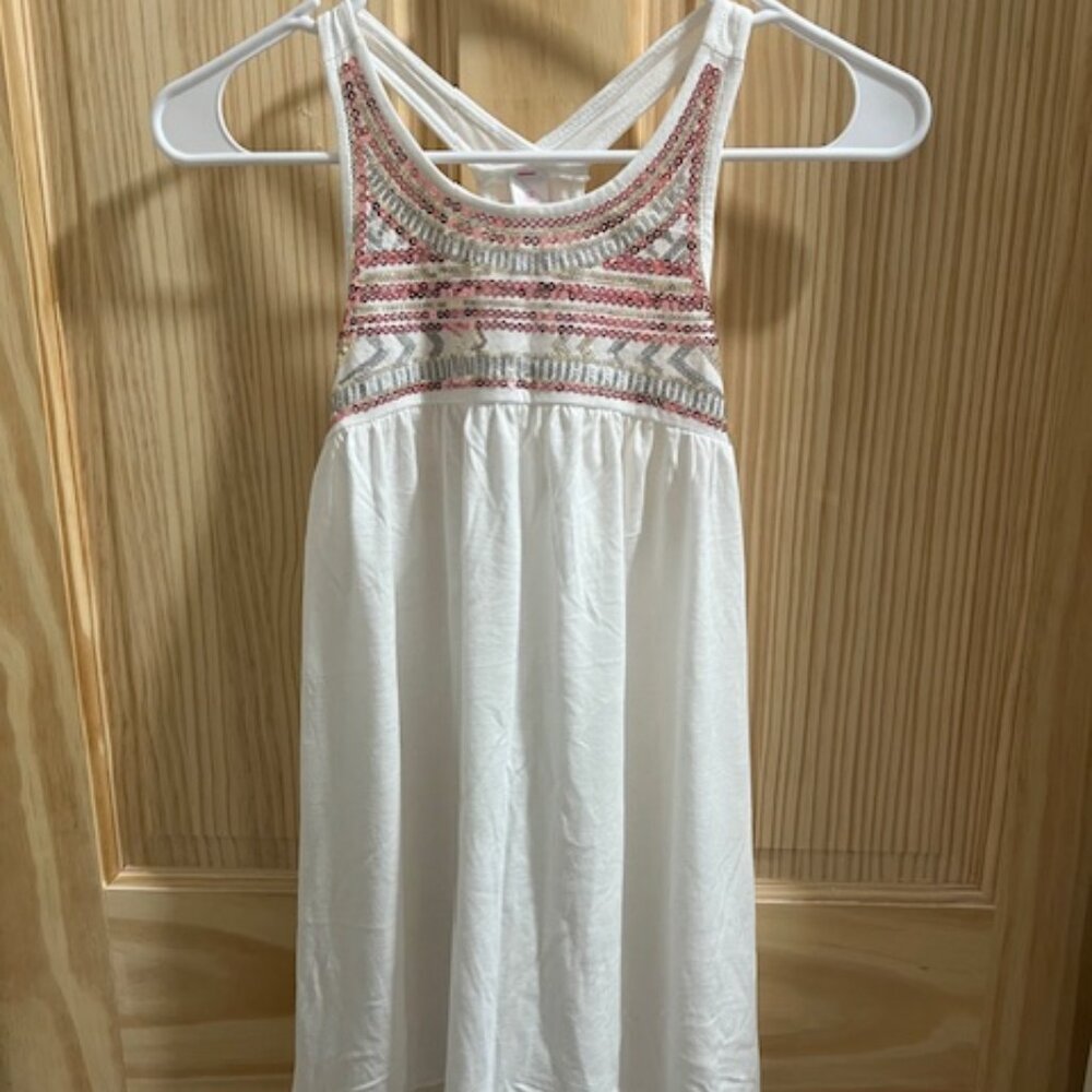 "No Boundaries" white‎ babydoll-style top with pink and gold sequins around neck